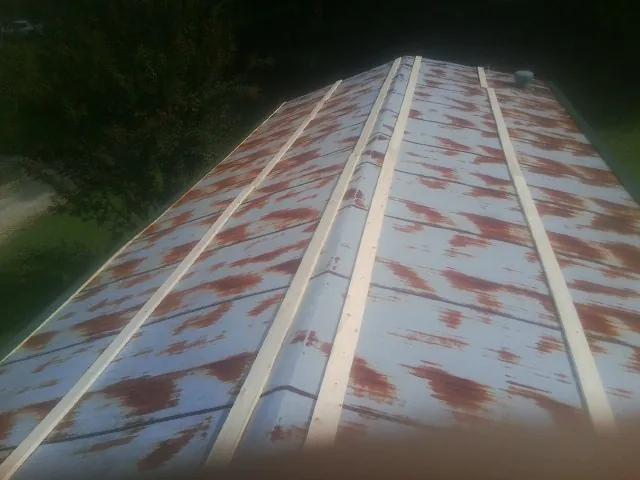 Rusted metal roof panels with new wood purlins before replacement — Storm Damage Roof Repair in Ducktown by Roofing Brothers