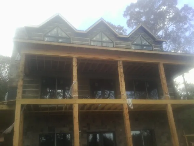 Dormers and porch framing on a large log home under construction — Roof Coating work by our crew in Ducktown