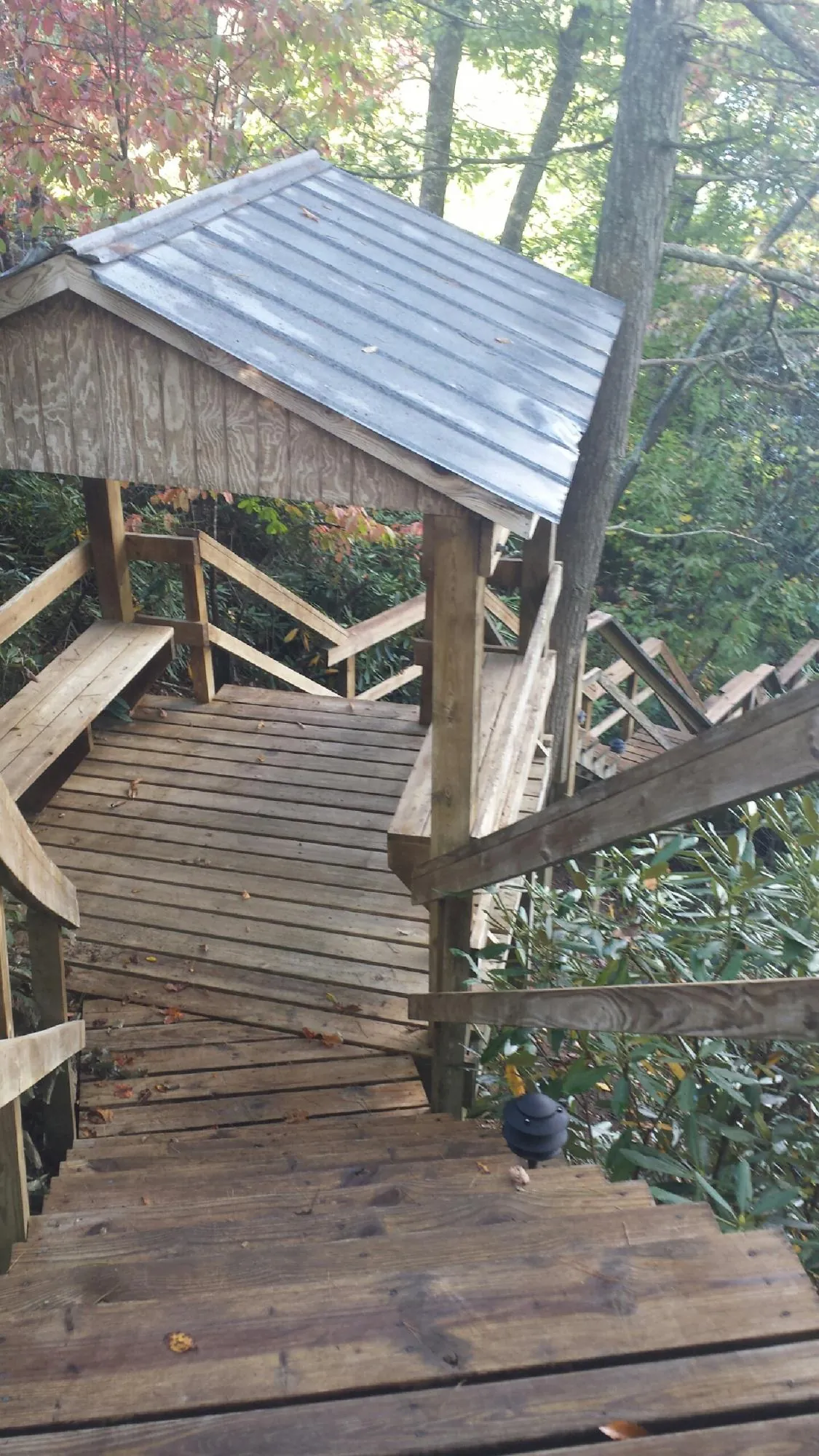 Metal roofed shelter over wooden steps on a wooded walkway — Skylight Repair & Installation work by our crew in Ducktown