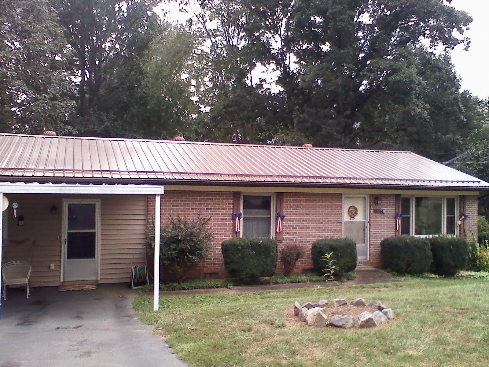 Bronze metal roof and carport on a brick ranch home — Roof Repair work by our crew in Ducktown