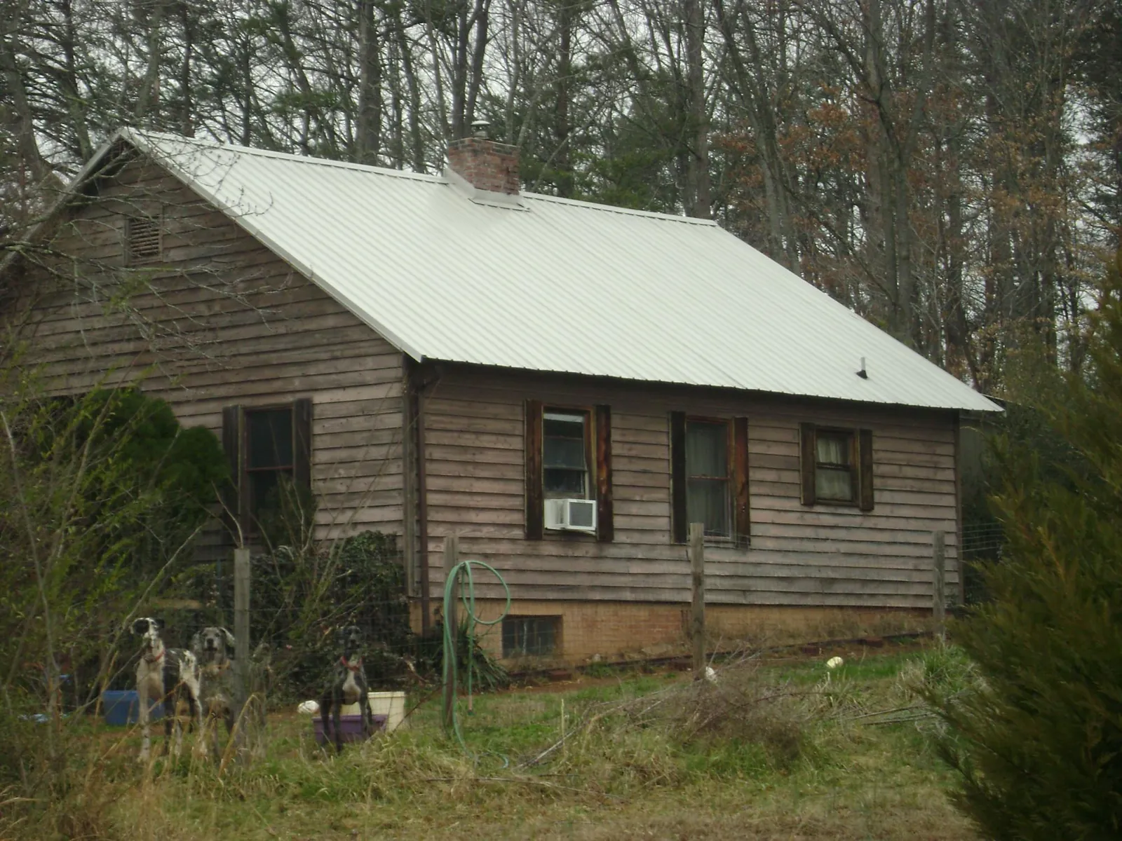 White metal roof on an old wood sided farmhouse, from a Metal Roof Installation job in Ducktown